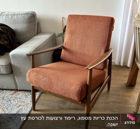 כורסה כתומה עם ריפוד עבה על רצפת עץ